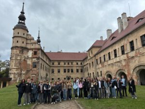 Eine Gruppe Schüler vor einem Denkmal.